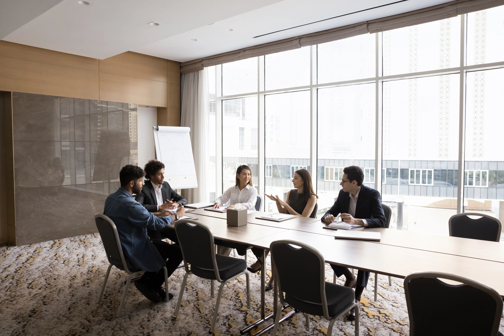 Multiethnic team of project managers talking at large table