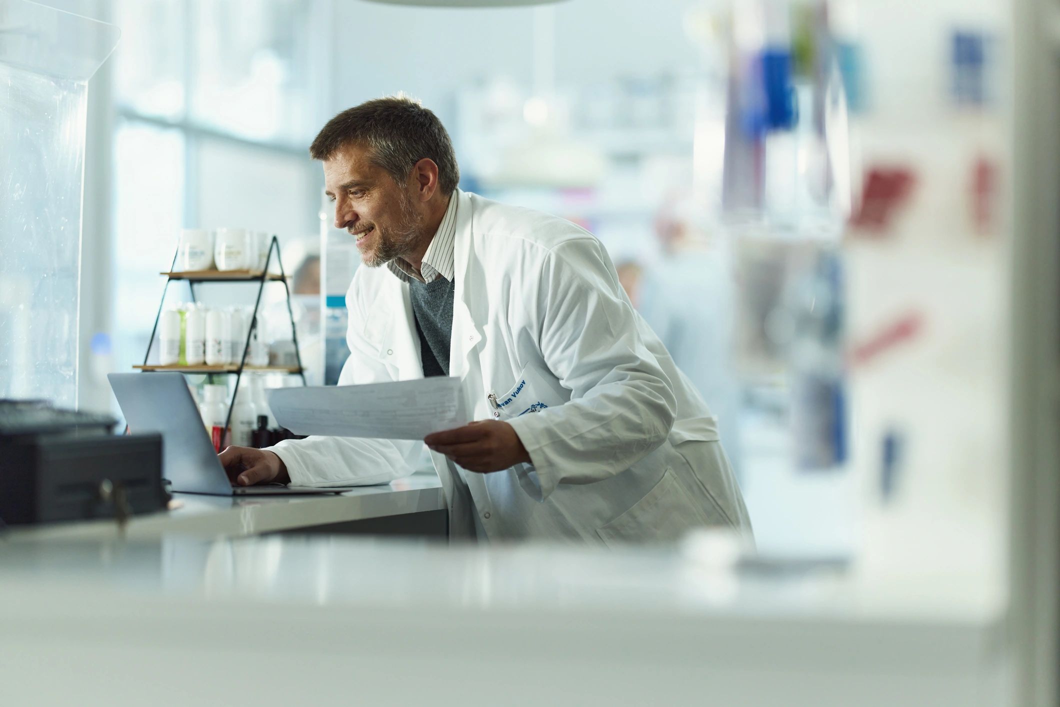 Healthcare professional reviewing reports on a laptop