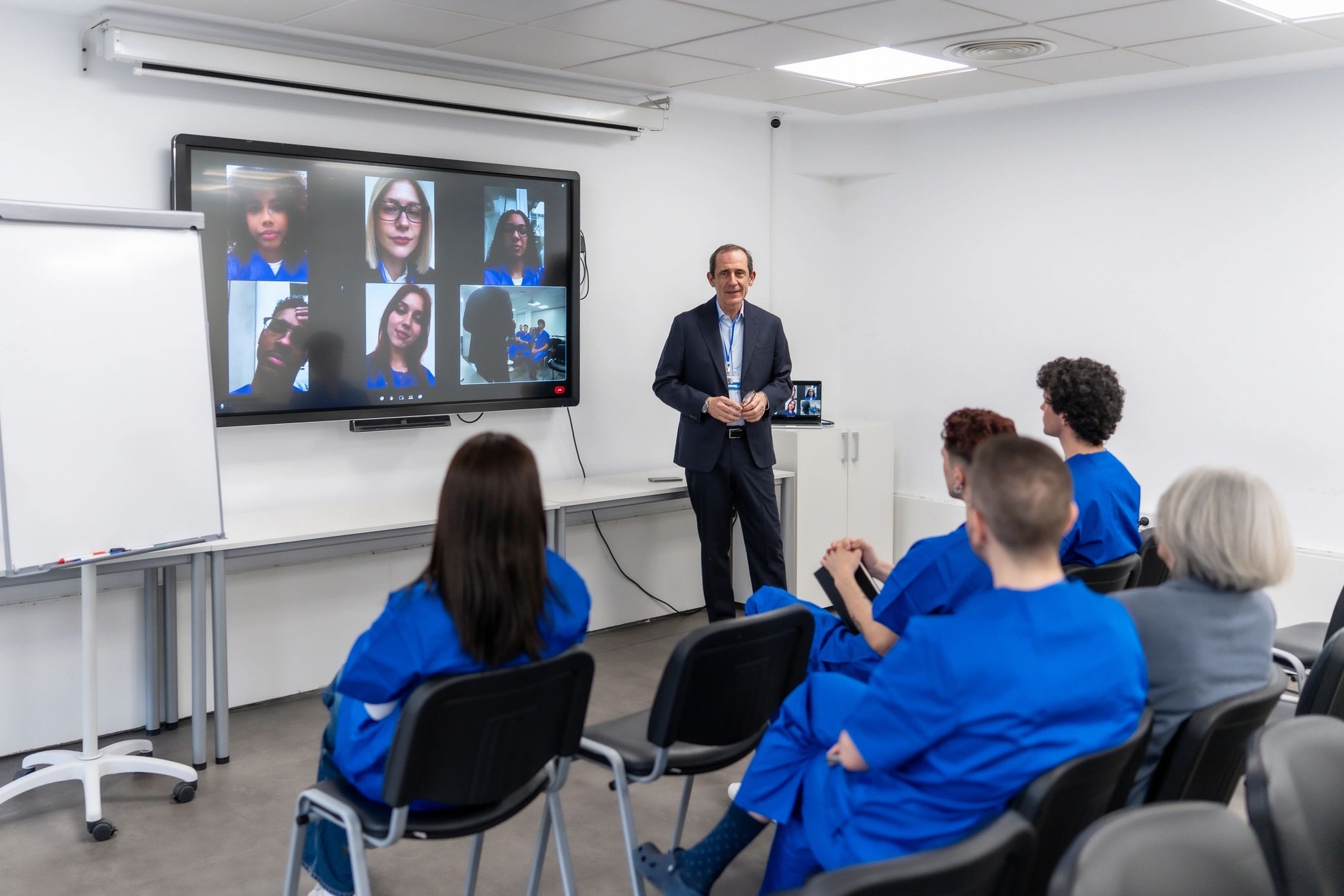 Professor leading hybrid medical education seminar using video conferencing